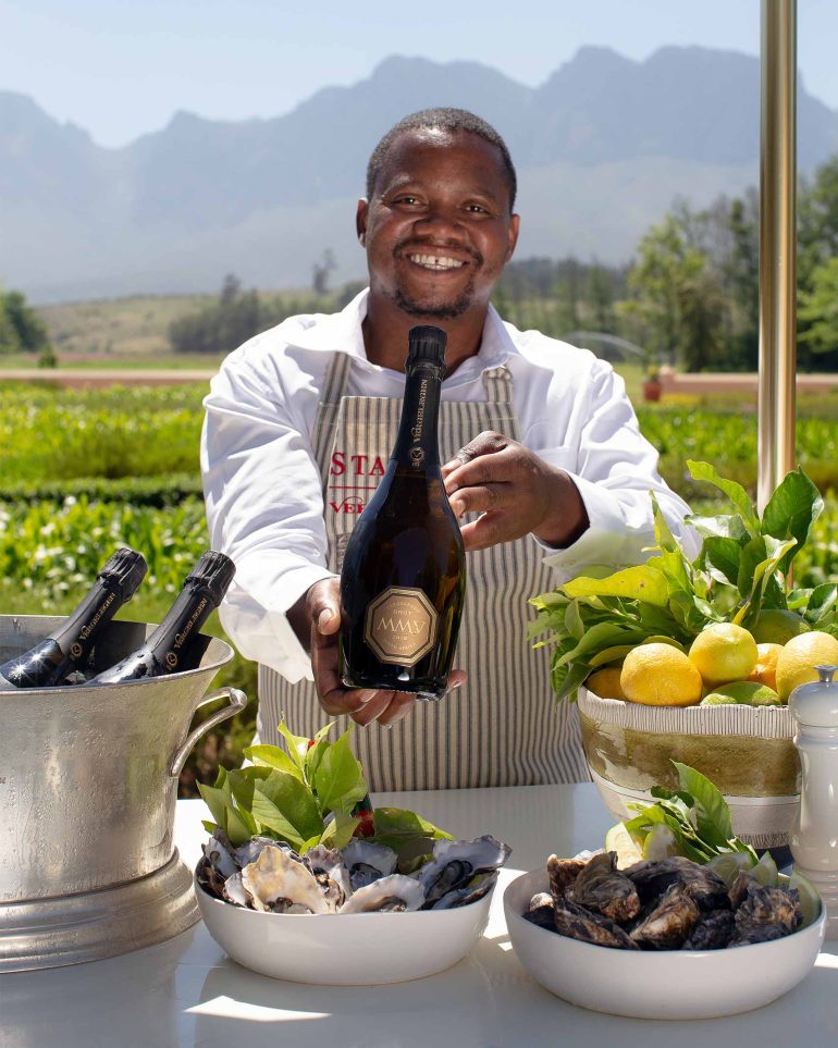 A team member holds up a bottle of wine at Vergelegen Wine Estate, Western Cape, South Africa