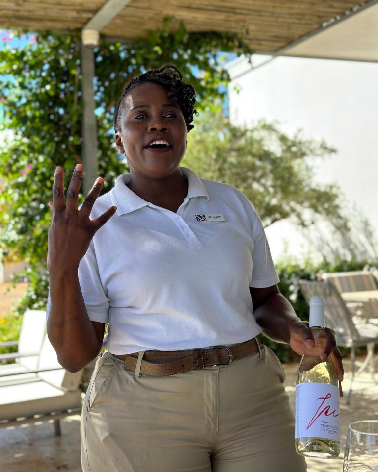 Team member Briggite at Morgenster Estate talks visitors through a wine-tasting, Western Cape, South Africa