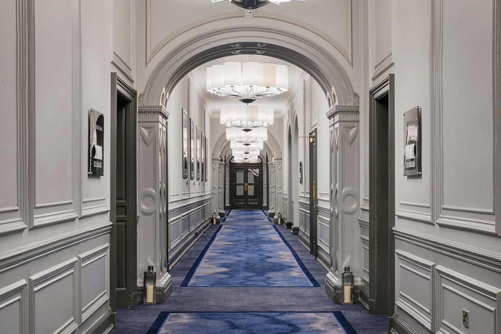 A Victorian-style hallway with lapis blue carpet at voco Grand Central, Glasgow, Scotland.