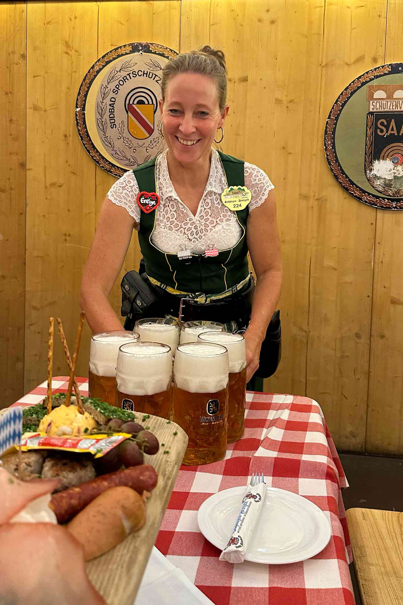 A traditionally dressed female staff member carrying large jugs of beer at the MOktoberfest.