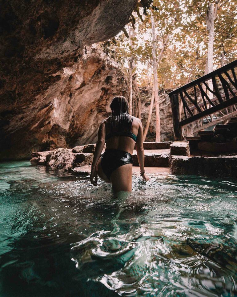 A woman ascends from a cenote on the Riviera Maya, Mexico