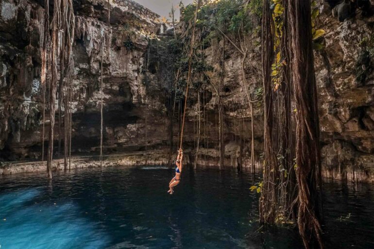 A woman swings over a cenote on the Riviera Maya, Mexico