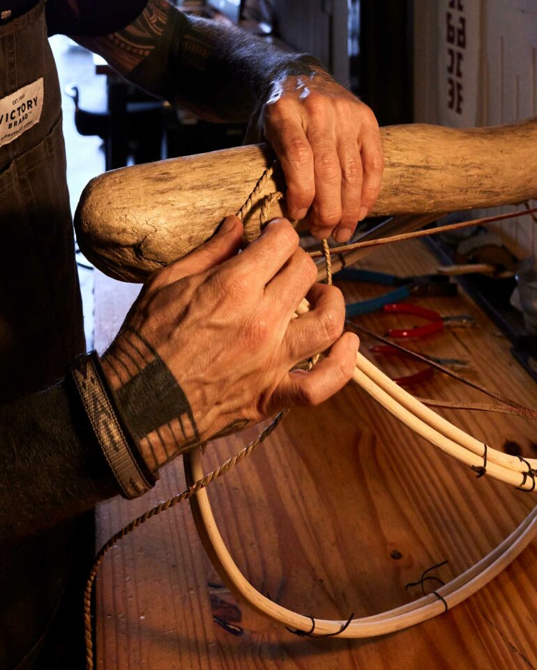 Close-up of Dax's hands creating a woven basket.
