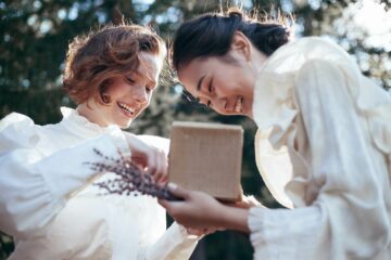 A same-sex couple opens a gift together.