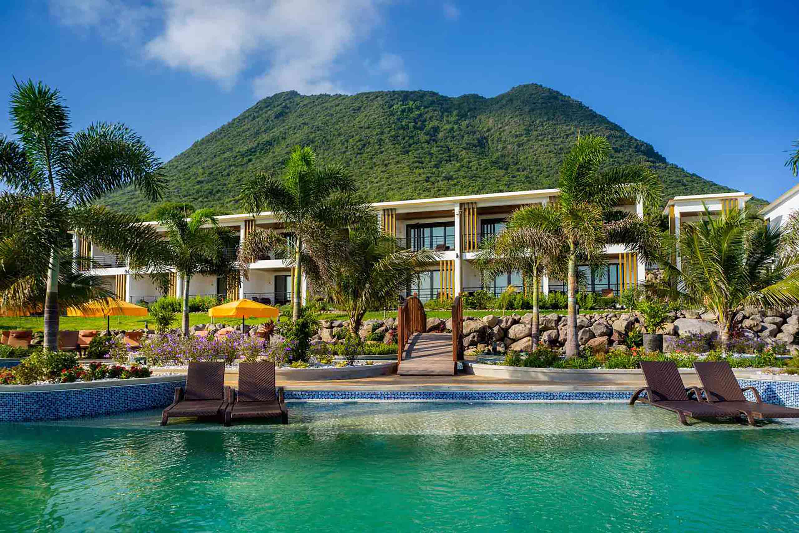 Golden Rock Resort outdoor pool with a lush green mountain in view.