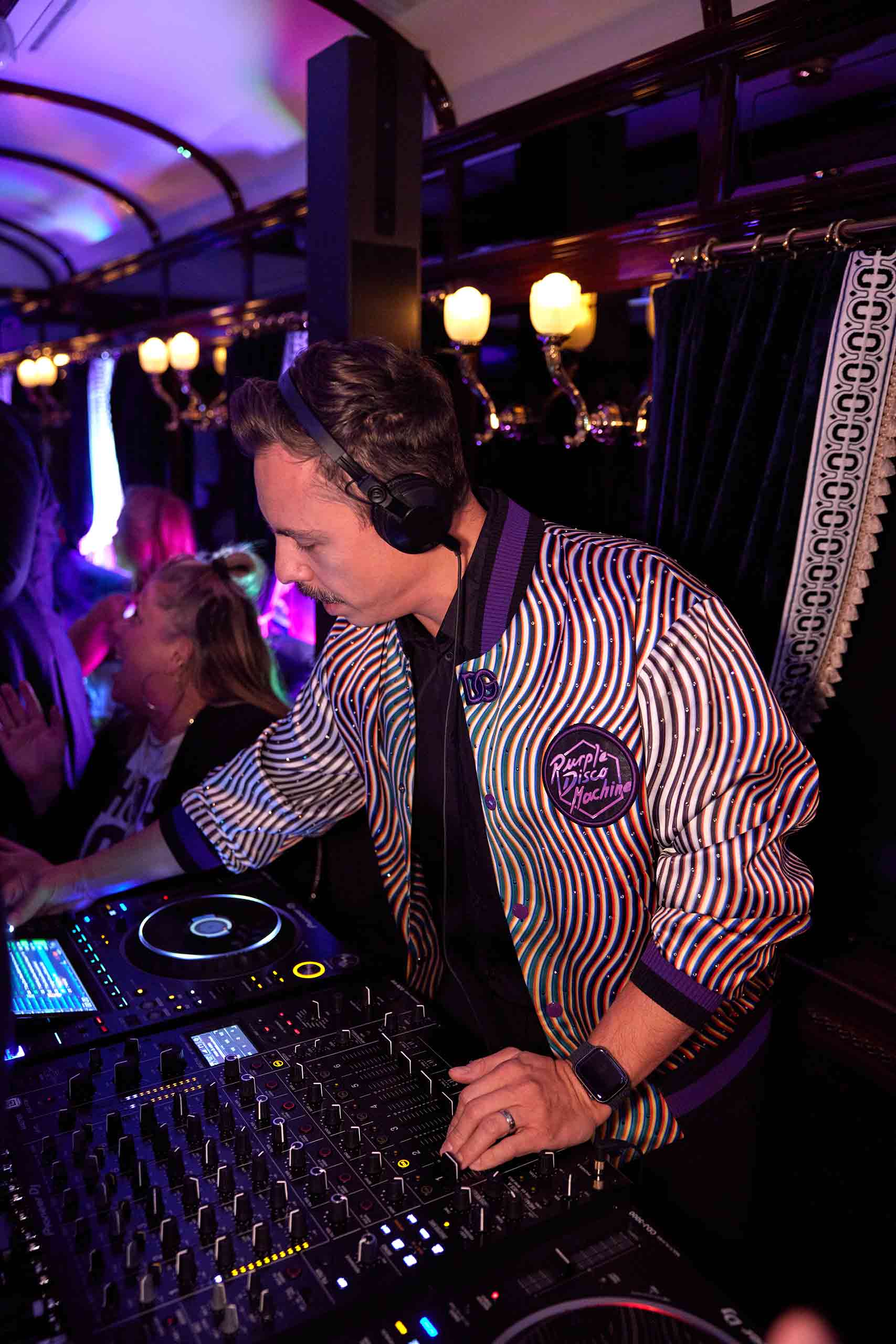 A DJ performs within the train carriage. 