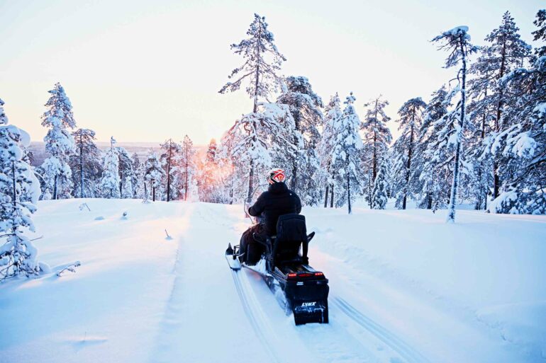 A man rides a snowmobile in the Arctic Circle, Finland