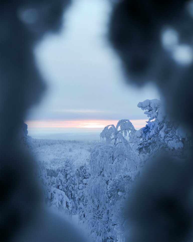 The sun rises over a winter landscape in Finnish Lapland