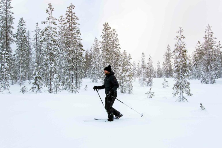 A tourist goes for a walk in a wintery landscape in Finnish Lapland