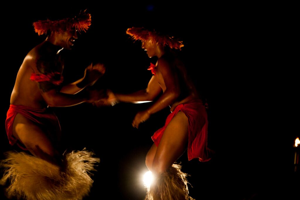 A man and woman engaging in a traditional Polynesian dance.