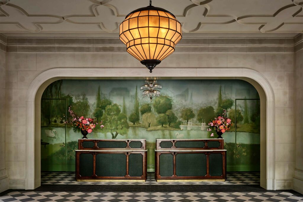 Stylish lobby at the Four Seasons Boston with a verdant art mural. The hotel was reimagined by designer Ken Fulk.
