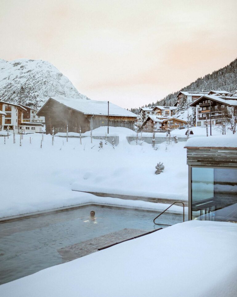A guest swims in an outdoor pool at Hotel Arlberg, Lech, Austria