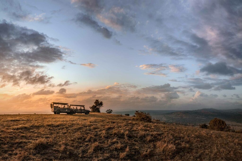 Safari vehicles look out over the savannah at Lengishu, Borana Conservancy, Kenya