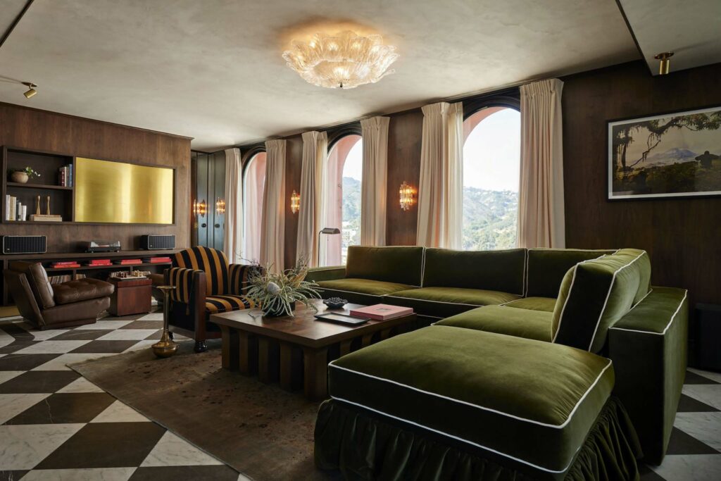 Penthouse suite with a plush green couch and wooden table.