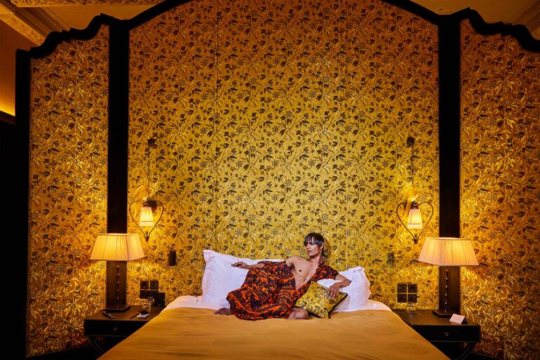 Namal Lanka poses in a bed at l'oscar London, United Kingdom