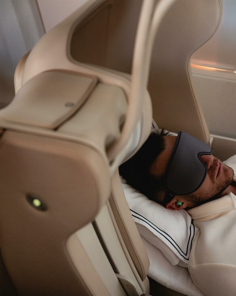 A male private jet passenger sleeping with an eye mask on.