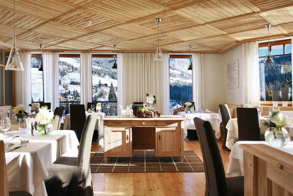 A restaurant offers views of the snowy slopes outside Hotel La Majun, La Villa, Alta Badia, Italy