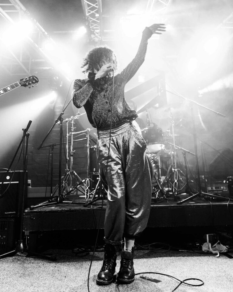 Wearing silver pants, Al Clapper performs on stage in Cape Town, South Africa