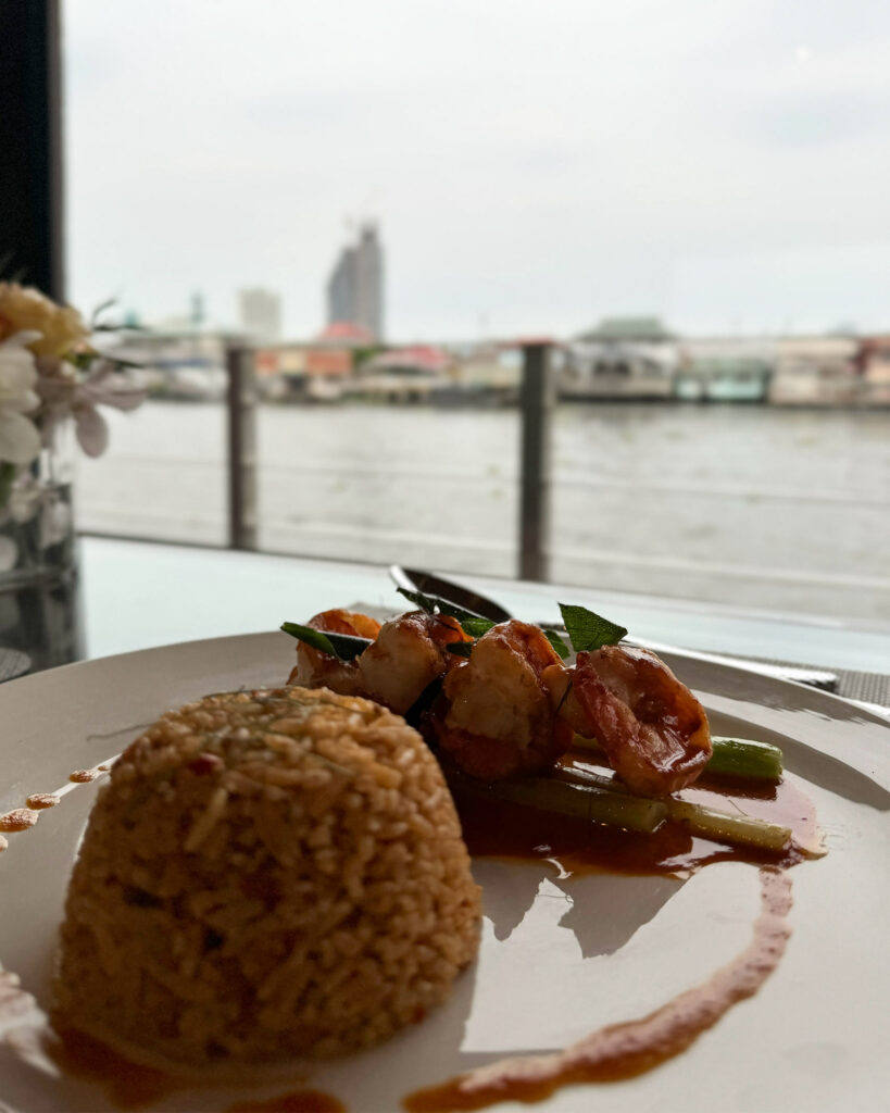 Dinner of sauteed prawn and rice aboard Loy Pela Voyages' new vessel, with river views.