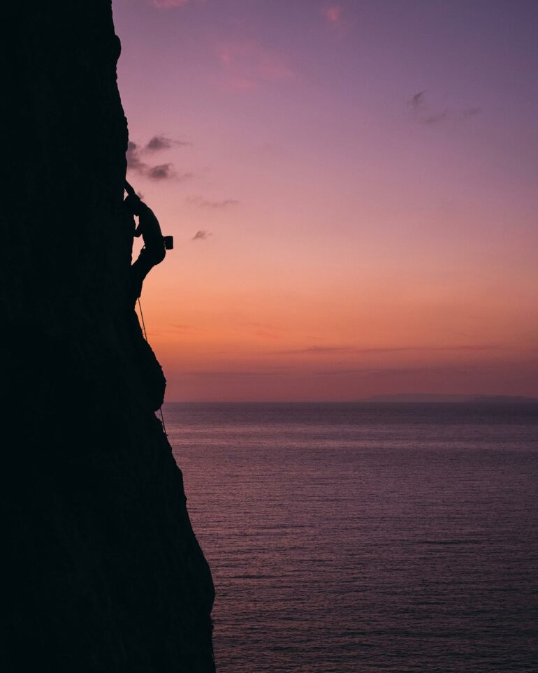 A rock climber climbs during sunset on Kalymnos, Greece