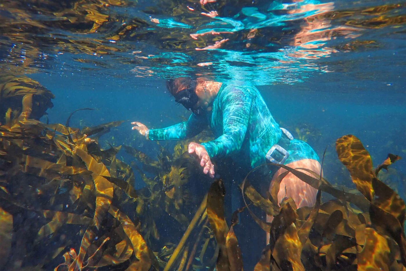 A female snorkeler helps with a beach clean-up organised by The Beach Co-op, Cape Town, South Africa