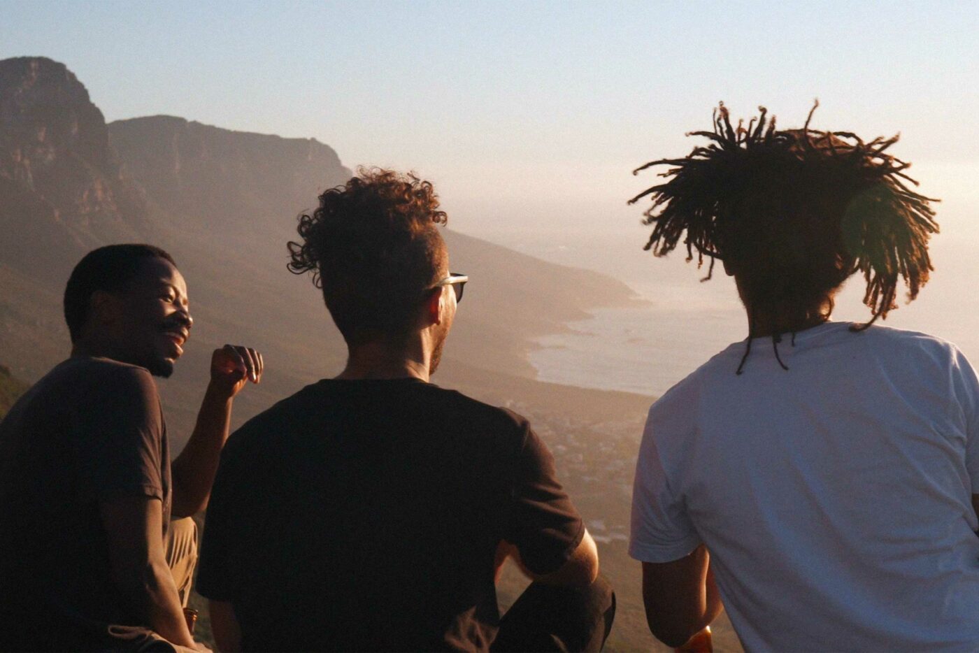Hikers look out over the sea while the sun sets in Cape Town, South Africa