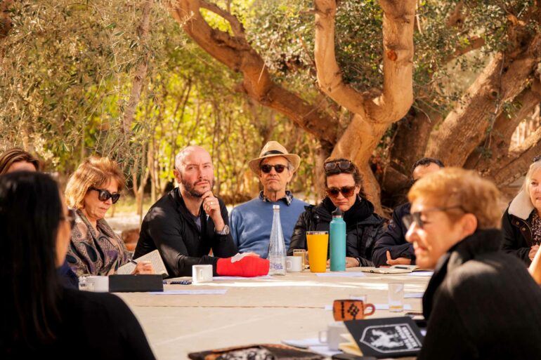 Attendees gather around a table during a writing retreat by Silk Road Slippers, Marrakech, Morocco