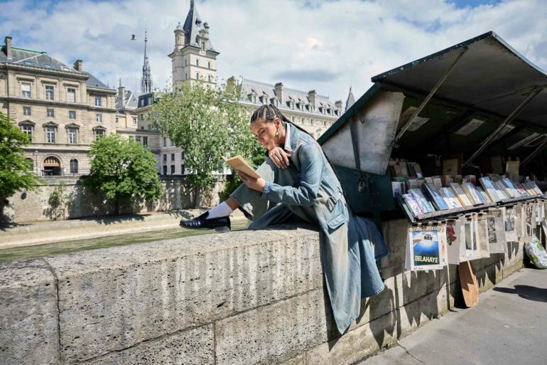 Koko Barno reads along the Seine in Paris, France