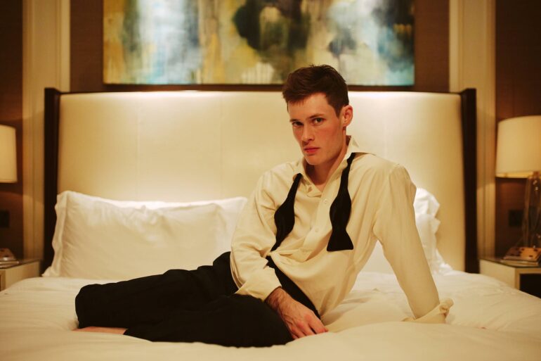 Jill Leflour poses for a picture on a bed inside The Corinthia Hotel in London, United Kingdom