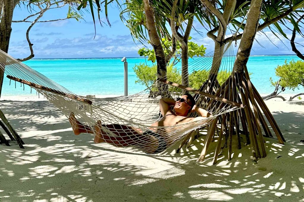 Man in a hammock to a paradise backdrop of French Polynesia