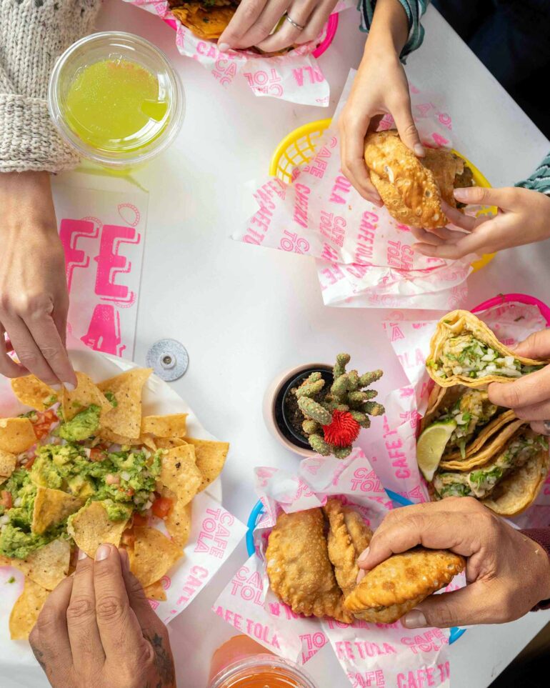 Friends share a meal at Café Tola in Chicago, Illinois, USA