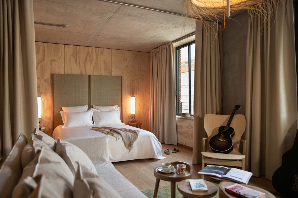 A neutral-coloured suite at Mob House. A guitar sits on one of the chairs.