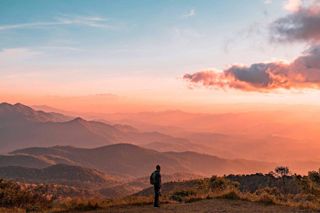 Man standing in Northern Thai mountains at sunset, tailor-made Thailand