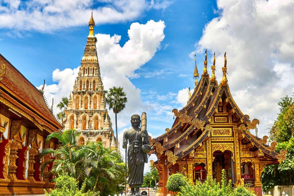 Temple complex, gold pagodas and buildings with statue in front, tailor-made Thailand
