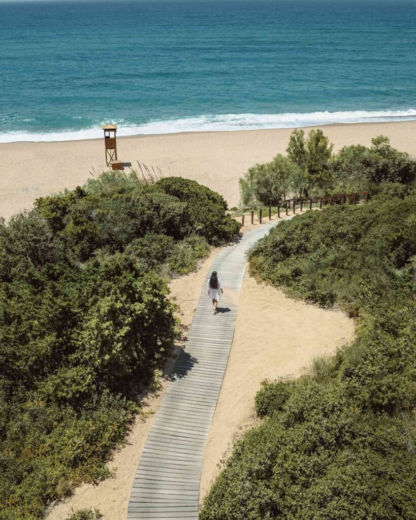 Woman walking on boardwalk to the beach