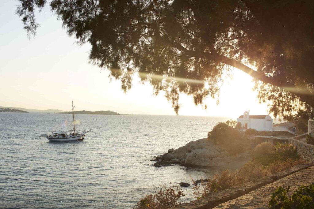 View at sunset of an old yacht and church in Mykonos