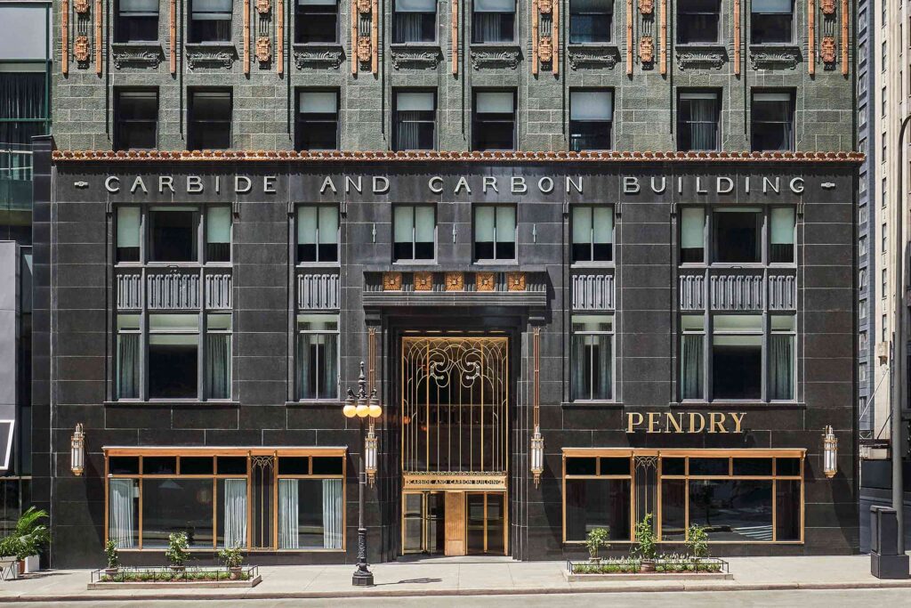 Exterior of the Carbon and Carbide Building in Chicago, now the Pendry Chicago with gilt gold trimmings, black frontage, art deco features and green terracotta tiles