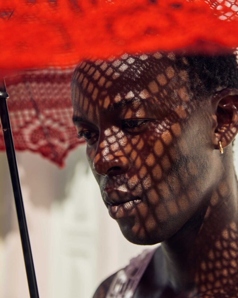 Fah Sampaio models a red parasol in Salvador, Brazil