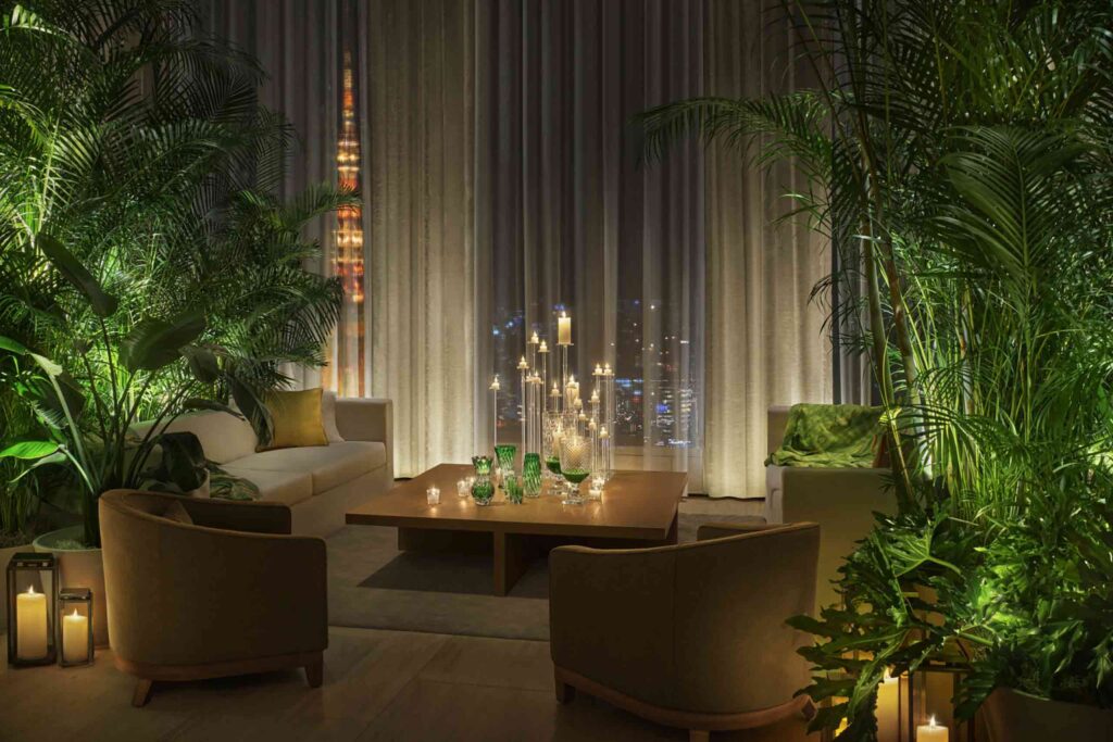 Emerald themed seating area, with green glassware, cushions and foliage