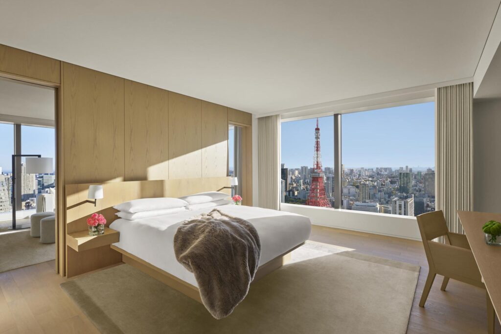 Clean white bedroom with pine woodwork overlooking Tokyo Tower at the Tokyo EDITION Toranomon
