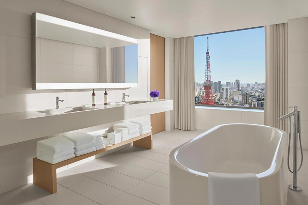 Clean white bathroom with pine woodwork overlooking Tokyo Tower at the Tokyo EDITION Toranomon