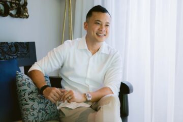 Hotelier Bayu Saworno smiles to camera, wearing a white shirt. He is a young, Balinese man