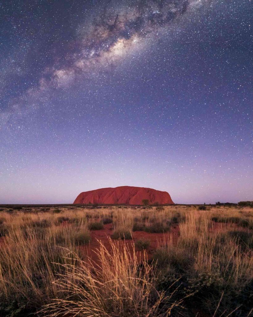 Uluru or Ayers Rock glows red in the starry sky in Australia's Red Centre
