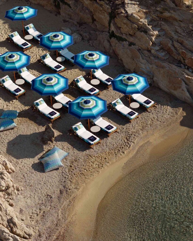 Blue Missoni umbrellas line a little private beach next to Cali Mykonos in Greece