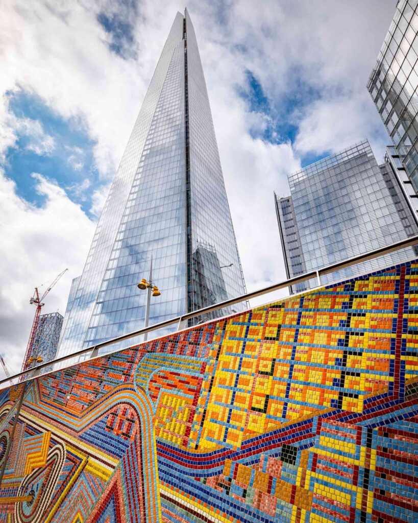 The Shard in London towers over a multi-coloured moasic wall