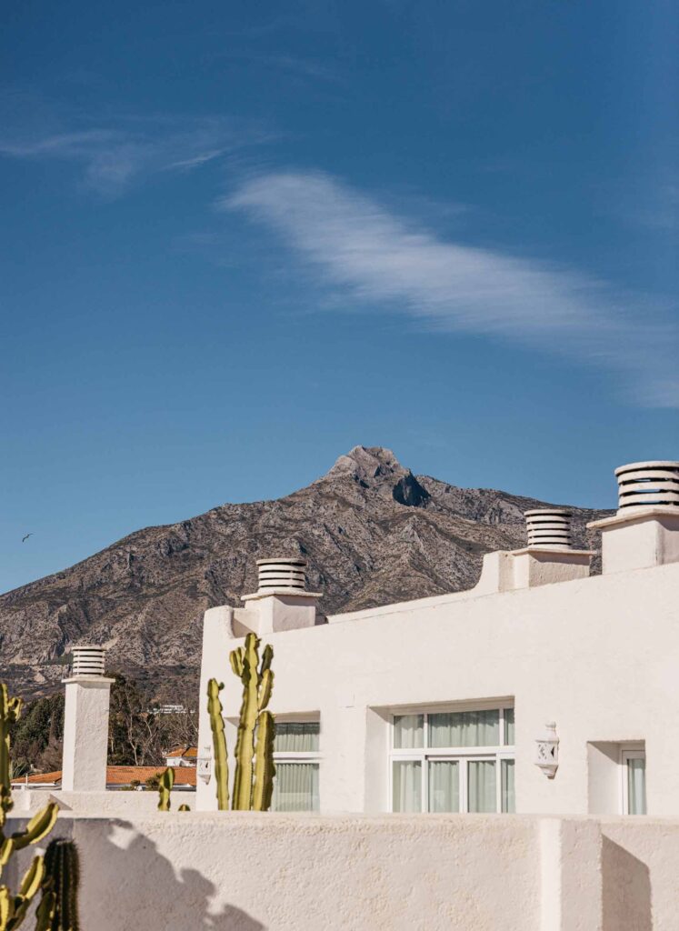 Crop of a white building with a mountain and blue sky in the background