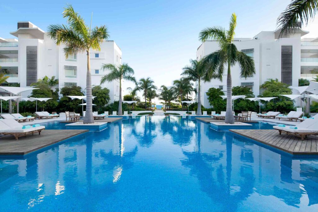 Pool deck flanked by palm trees, Wymara Turks and Caicos
