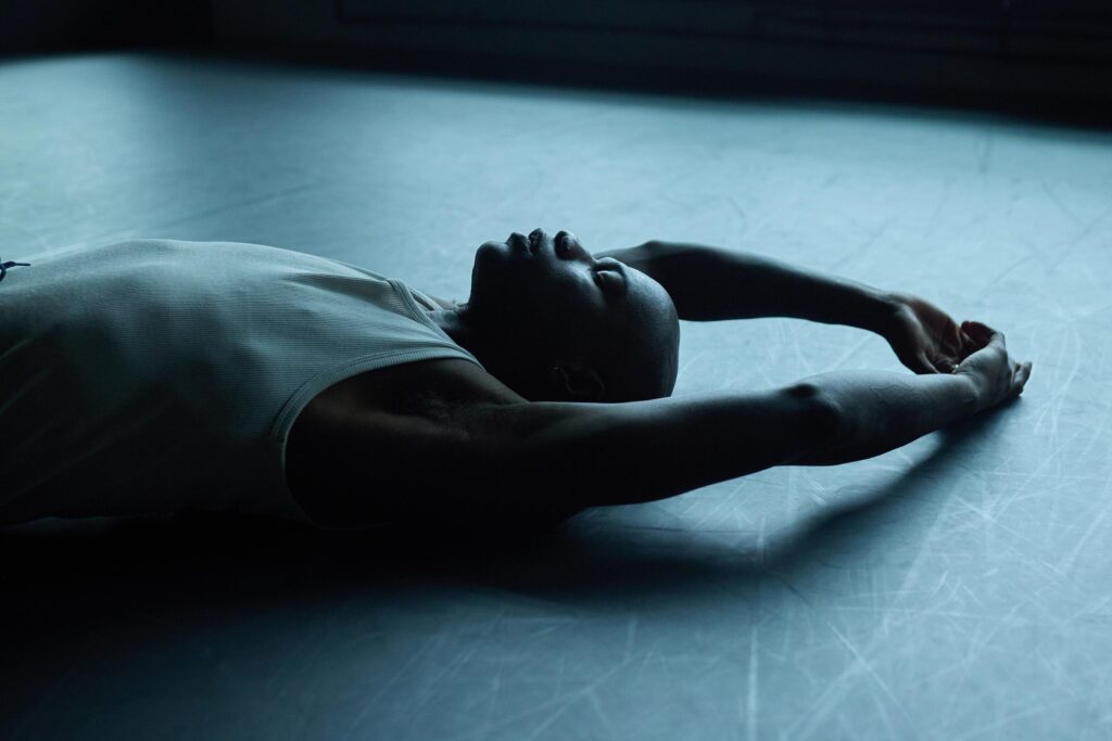 Folu Odimayo lying on the floor of a dance studio in Stratford, London, UK