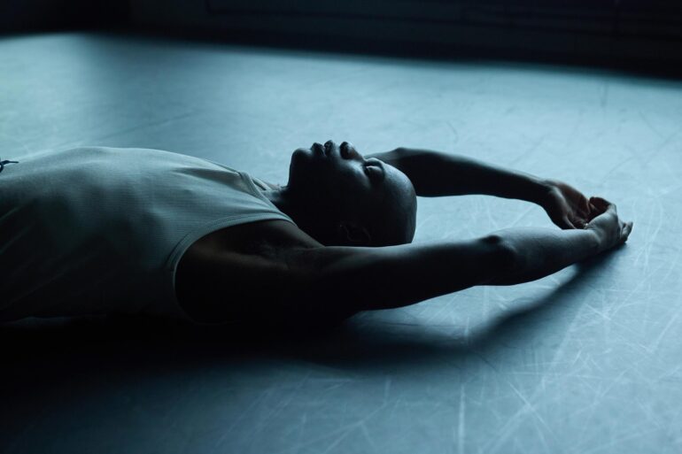Folu Odimayo lying on the floor of a dance studio in Stratford, London, UK