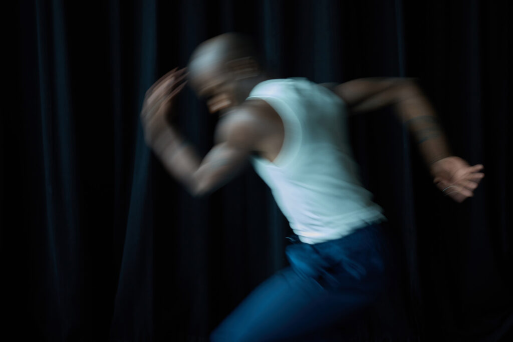 Blurry shot of a model running in front of a black backdrop